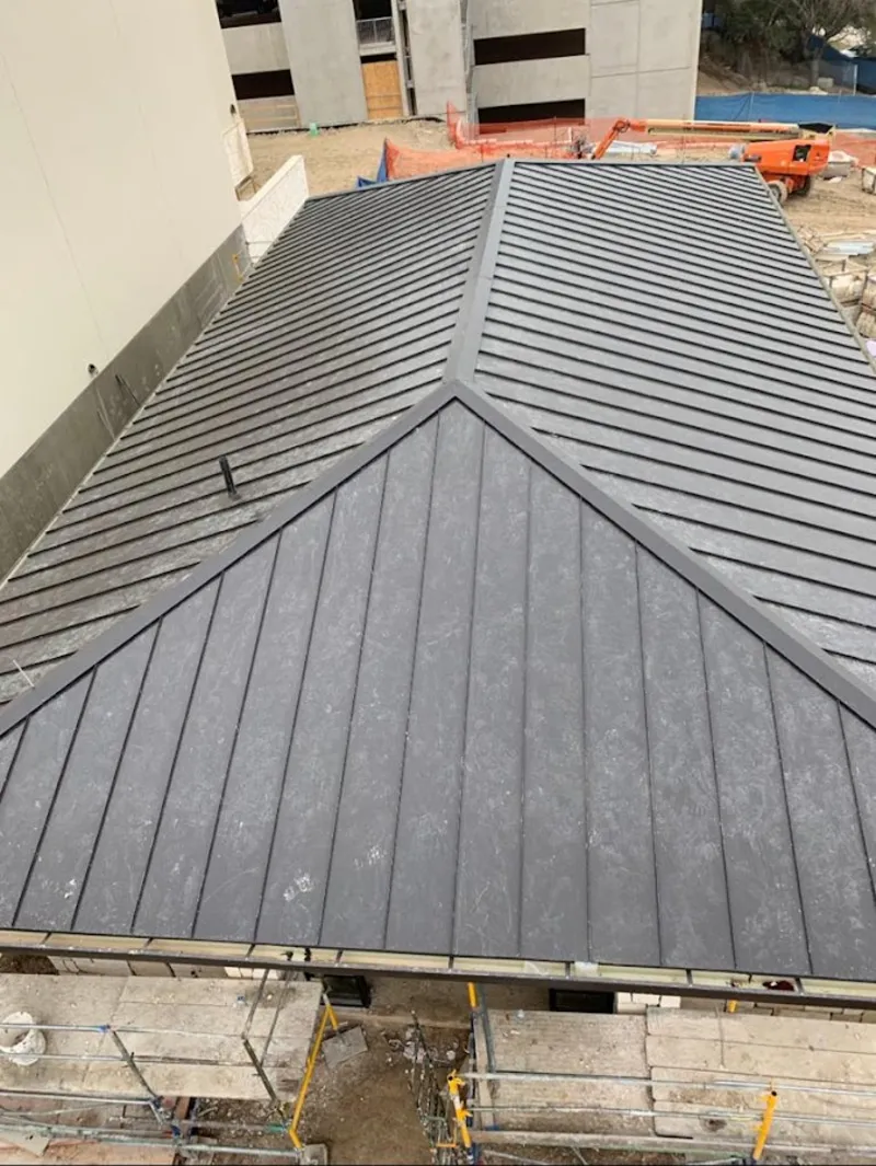 Commercial metal roof construction with crane equipment in Auburn